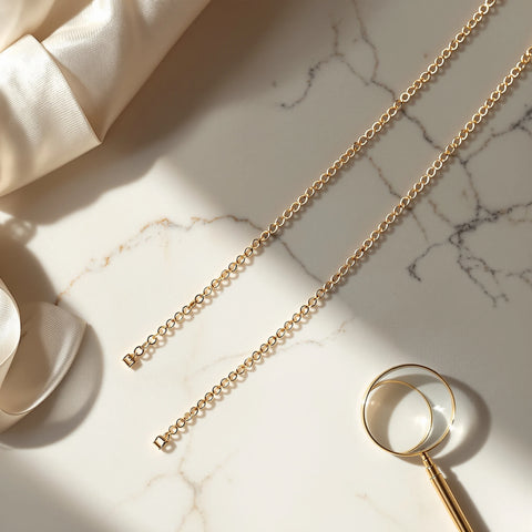 14K vs 18K gold comparison — two gold chain necklaces showing color difference on white marble