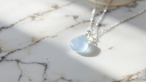 Angelite pendant necklace on white marble — pale blue angel stone jewelry