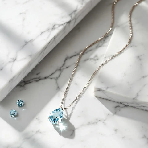Aquamarine pendant necklace on marble — aquamarine meaning and March birthstone guide