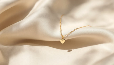 A sterling silver heart-charm bracelet displayed on a neutral surface
