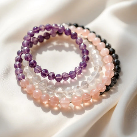 Several genuine gemstone crystal bead bracelets arranged on a neutral background