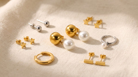 Several pairs of affordable sterling silver and gold-plated earrings arranged on a linen surface