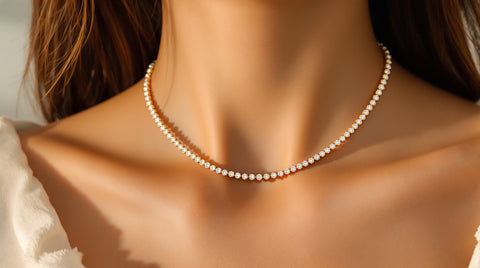 Woman wearing a delicate cubic zirconia tennis necklace at the collarbone, close-up styling shot