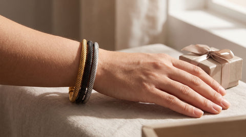 Woman wearing a gold chain cuff bracelet, a gift for mom, resting near a wrapped gift box