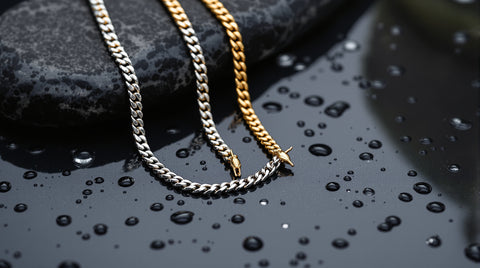 Stainless steel and gold-tone chain necklaces on wet stone with water droplets, showing water beading on the metal