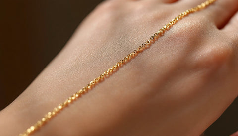 Close-up of a hand chain worn across the back of the hand, connecting a wrist bracelet to a finger ring