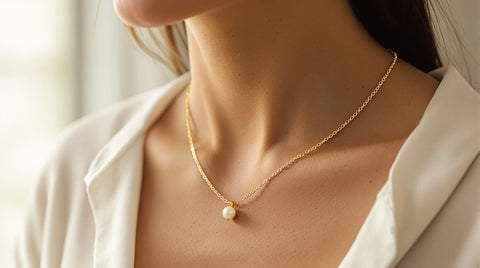 Woman wearing a layered pearl pendant necklace and gold chain necklace, close-up quiet luxury styling shot