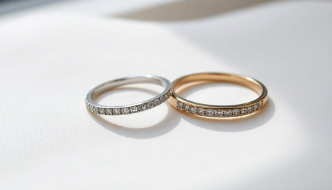A band of small clear stones set in a smooth channel next to a pave-set band on a soft neutral surface
