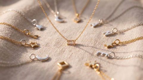 Assorted silver and gold-plated charms and a pendant necklace laid out together showing the size and attachment difference