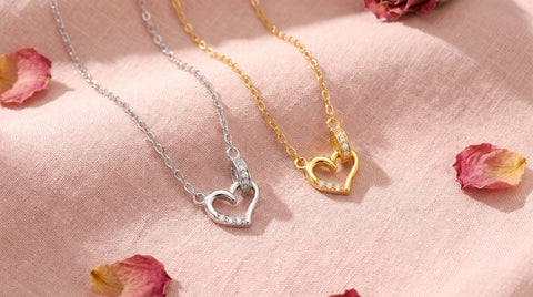 AJLuxe open heart necklaces in silver and gold with CZ accents on blush linen