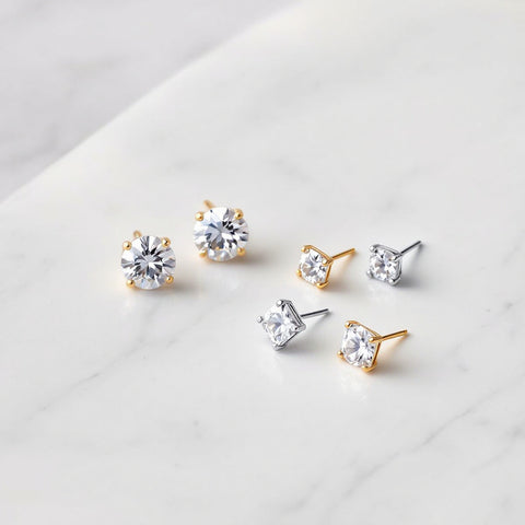 Five pairs of cubic zirconia stud earrings in different settings and cuts flat-lay