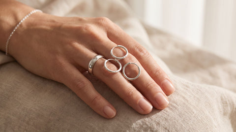 Close-up of a hand wearing polished sterling silver jewelry