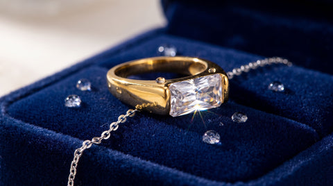 Close-up of a sparkling faceted crystal ring and silver chain on a dark velvet surface
