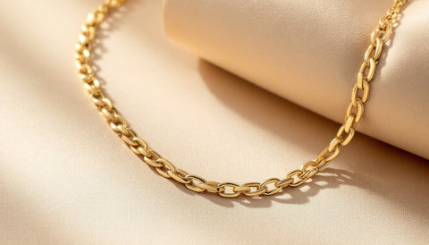 A gold figaro chain necklace with alternating link pattern displayed on a neutral surface