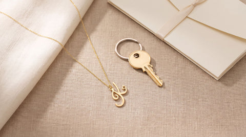 Gold initial necklace styled as a realtor closing gift with keys