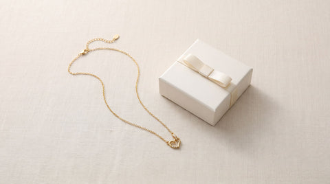 Dainty gold circle heart necklace styled as a minimalist gift