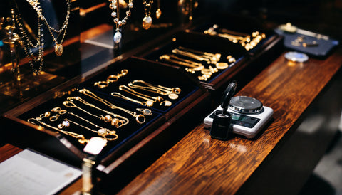 Gold jewelry displayed on velvet trays inside a jewelry store showcase