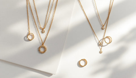 Minimalist gold jewelry pieces from two different brands laid out side by side for comparison