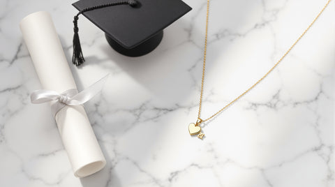 Graduation gift ideas for her — heart initial necklace with cap and diploma flat lay