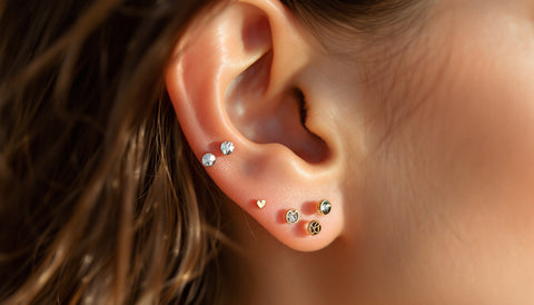 Close-up of a healed ear wearing hypoallergenic sterling silver and gold-plated stud earrings