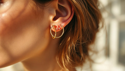 Close-up of hypoallergenic gold-plated sterling silver earrings worn in multiple ear piercings