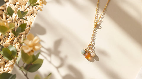 Natural gemstone charm necklace laid flat on a woven textured surface for a Local Eclectic legitimacy review