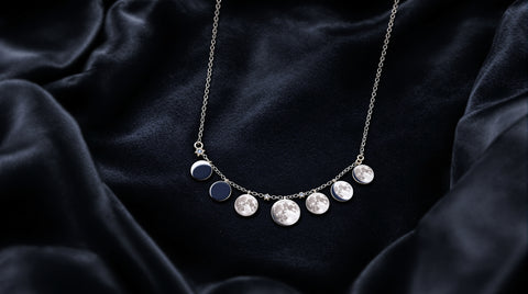 Moon phase necklace showing all 8 lunar phases on dark velvet — moon phase jewelry meaning guide