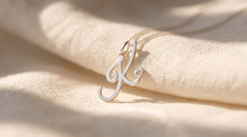 Sterling silver Morse code necklace pendant engraved with dots and dashes resting on linen fabric