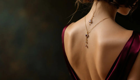 Delicate gold pendant necklace draped down the open back of a backless evening dress