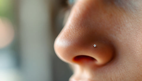 Close-up of a delicate silver nose stud worn in a healed nostril piercing