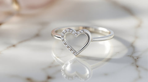 Elegant sterling silver heart promise ring on marble surface