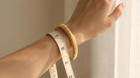 Measuring a small wrist with a soft tape to find the right bracelet size