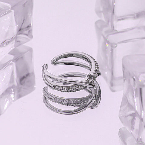 Sterling silver twisted ring with cubic zirconia pave along a double-line crossover twist, macro product photo