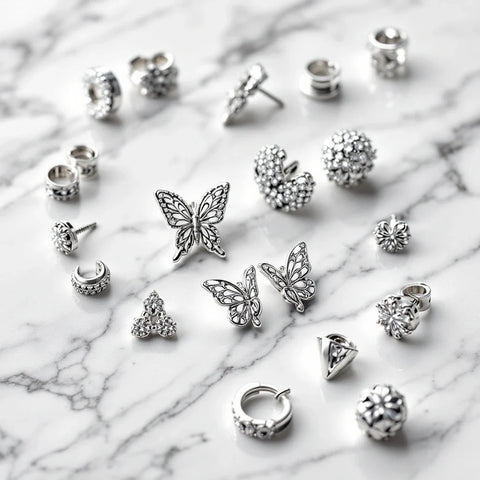 Types of earring backs — butterfly, screw, lever, latch, omega earring backs collection on white marble
