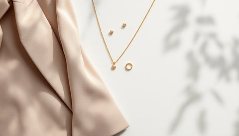 Small gold stud earrings and thin necklace styled as professional job interview jewelry
