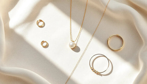 Assortment of affordable gold and silver jewelry pieces arranged on a soft neutral background