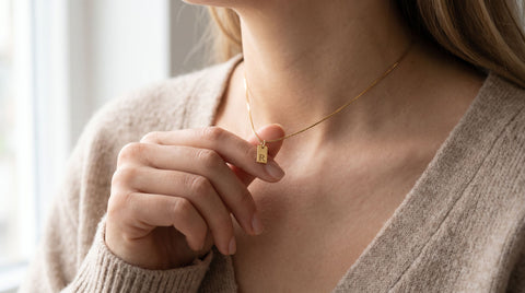 Woman wearing a personalized initial pendant necklace in 18K gold-plated sterling silver