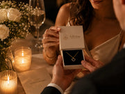 AJLuxe jewelry gift box with gold necklace during a romantic candlelit anniversary gift moment