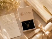 AJLuxe jewelry gift box with gold necklace beside graduation card for an elegant graduation gift moment