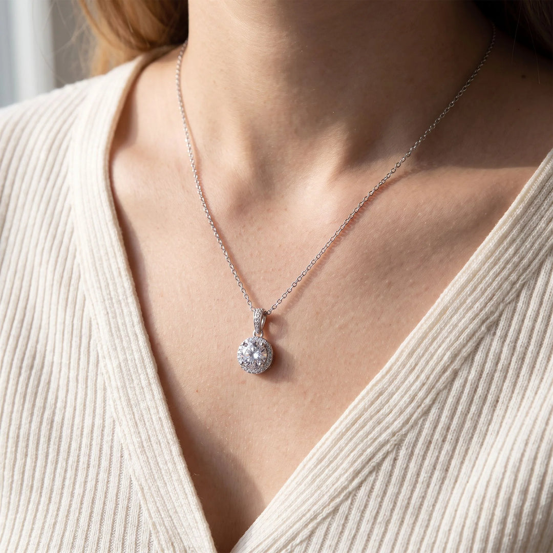 Round Halo Pendant Necklace worn at the collarbone, close-up, rhodium plated finish