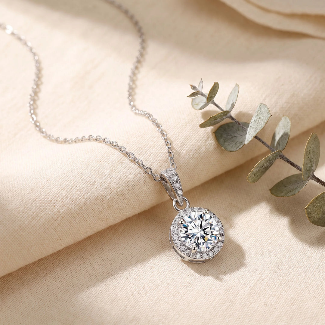 Round Halo Pendant Necklace lifestyle flat lay on linen with eucalyptus, rhodium plated finish