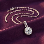 Load image into Gallery viewer, Round Halo Pendant Necklace coiled on purple satin, editorial lifestyle photo
