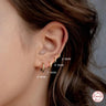 A person wearing a pair of silver hoop earrings, with the dimensions of the earrings labeled.