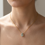 Load image into Gallery viewer, Aquamarine teardrop pendant necklace worn at the collarbone in natural daylight — 18K gold plated 925 sterling silver
