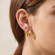 Earring Stack Set worn on one ear — 15mm gold dome hoop, 8mm gold huggie and 5mm CZ stud stacked together