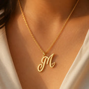 Heart initial necklace in 18K gold plated sterling silver — personalized script M pendant with heart detail, worn on model