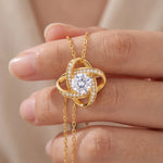 Lade Bild in die Galerieansicht, Love Knot Necklace held close-up showing the CZ center stone and pave detail, 18K gold plated finish
