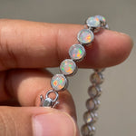 Lade Bild in die Galerieansicht, Rainbow Moonstone Tennis Bracelet close-up, stones held in hand showing play-of-color
