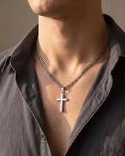 Man wearing the men's cross necklace on a Cuban link chain with an open-collar shirt