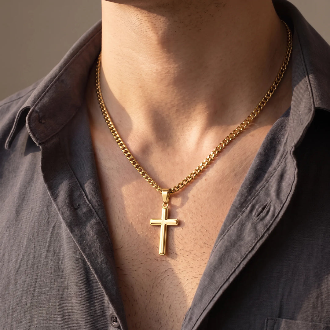 Man wearing the gold cross necklace on a gold-tone Cuban link chain with an open-collar shirt